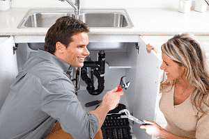 Image of a plumber) speaking to a customer about a repair offered with a flat rate price.